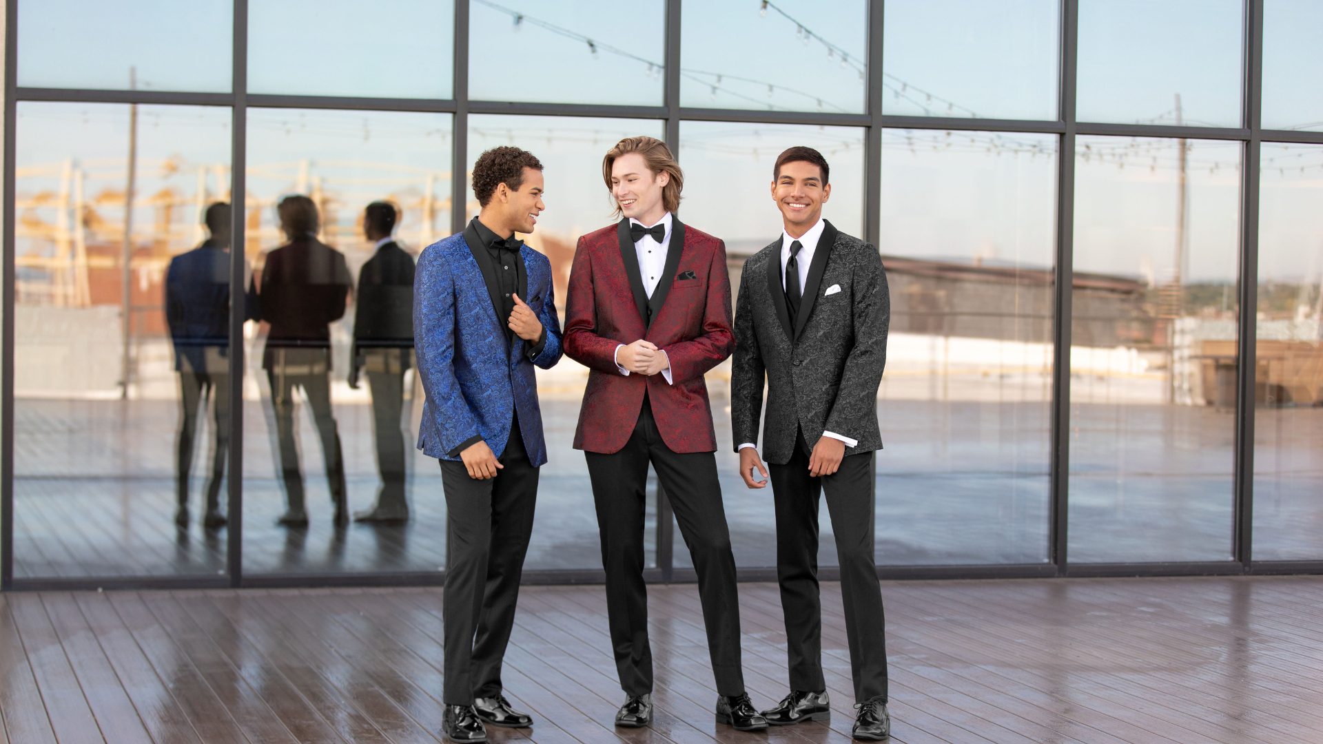 3 high school students outside the dance, ready for the prom, showing off their tuxedo and suit rentals